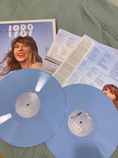 two blue records sitting on top of a bed