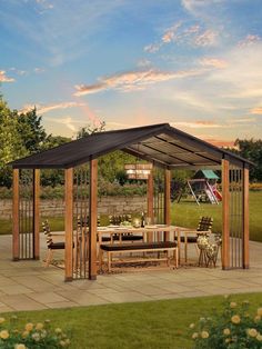 a gazebo sitting on top of a patio next to a lush green field