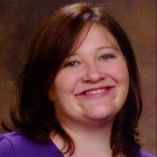 a woman in a purple shirt smiling at the camera