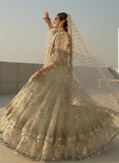 a woman in a wedding dress is posing for the camera with her hand up to her face