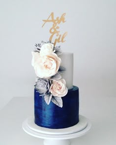 a blue and white cake with flowers on top