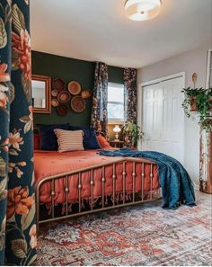 a bed sitting in a bedroom next to a window with curtains on top of it