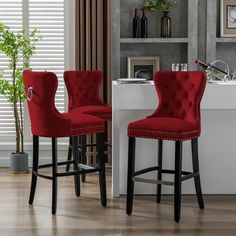 two red chairs sitting next to each other in front of a white counter and window