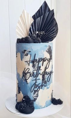 a blue and white birthday cake decorated with paper fans