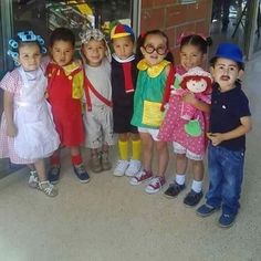 a group of young children standing next to each other in front of a store window