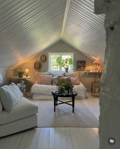 an attic bedroom with white walls and wood floors