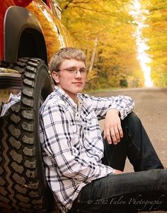 a young man sitting on the back of a truck