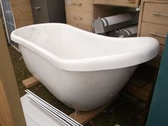 an old bathtub is being worked on in a yard with other woodworking tools