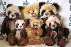 a group of teddy bears sitting next to each other on top of a bed together