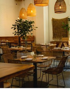 an empty restaurant with wicker chairs and wooden tables set up for lunch or dinner