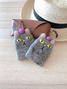 a pair of gray cat mitts sitting on top of a table next to a hat