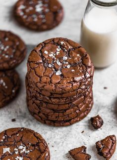 chocolate cookies with sea salt on top and milk in glass bottle next to them,