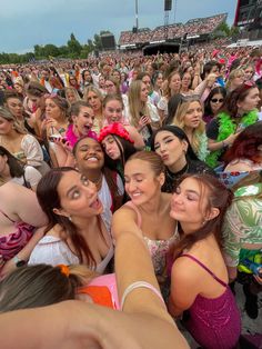 a group of young women standing next to each other in front of a large crowd