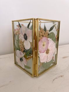 an open box with flowers on it sitting on a table