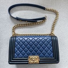 Authentic Chanel Lambskin Two-Color Medium Boy Flap In Navy & Black. Linear Quilted Border. The Bag Features A Matte, Distressed Gold Chain-Link Shoulder Strap With A Navy Leather Shoulder Pad, And A Gold Boy Cc Push Lock On The Front. This Opens The Bag To A Black Navy Interior With A Patch Pocket. I Haven’t Posted An Item In A While, But I Am Making Room In My Collection. As You Can See From My Sales, I Have A Consistent 5-Star Rating For Authenticity And Service. I Only Sell Items From My Personal Collection And I Am Extremely Careful With My Things. I Am Including Photos That Show Any Wear, But Please Rest Assured That The Item In-Person Does Not Show The Wear As Obviously In The Wa Navy Interior, My Things, Navy Leather, Star Rating, Making Room, Sell Items, My Collection, Chanel Bag, Shoulder Pads