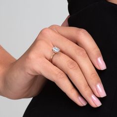 a woman's hand with a diamond ring on it