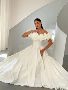 a woman in a white wedding dress posing for the camera