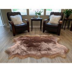 a living room with two chairs and a rug on the floor