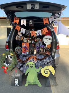 the trunk of a car decorated for halloween with decorations and other items in it's trunk