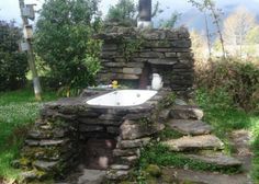 an outdoor hot tub in the middle of some rocks