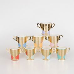 a group of gold cups sitting next to each other on top of a white table