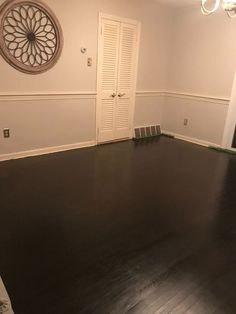 an empty room with hard wood floors and white walls