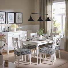 a dining room table set with chairs and place settings