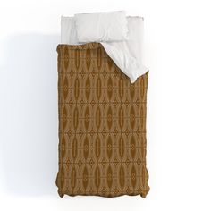 an image of a bed with a brown and white comforter on top of it