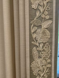 an embroidered curtain with flowers and leaves on it