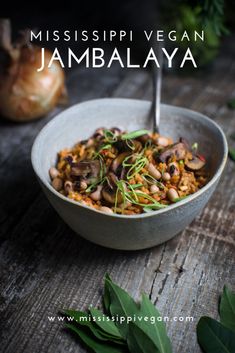 a bowl filled with food sitting on top of a wooden table next to green leaves