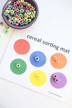 cereal sorting mat with beads on it next to a bowl of cereals and a cup of candy