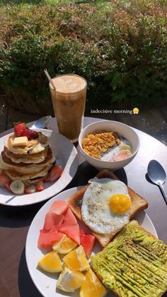 two plates filled with breakfast foods on top of a table