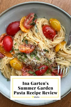 a white plate topped with pasta covered in tomatoes and herbs next to a fork on top of a wooden table