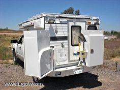 a white truck parked on top of a dirt field