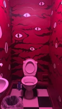 a bathroom decorated in pink and black with eyes painted on the walls, toilet seat cover and sink