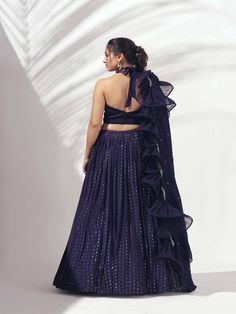 A three-piece Purple halter lehenga set from the Suruchi Parakh collection. This gorgeous georgette crepe lehenga is paired with a zardosi handwork satin blouse. The outfit is completed with a matching soft organza dupatta. The halter blouse has a feather neckline with a back tie-up. And, the dupatta has a beautiful touch of ruffle and zardozi handwork hemline. Festive Evening Lehenga In Georgette, Bollywood Style Evening Lehenga In Georgette, Evening Lehenga In Georgette With Traditional Drape, Evening Lehenga With Traditional Drape In Georgette, Evening Georgette Lehenga With Traditional Drape, Bollywood Style Georgette Lehenga For Evening, Georgette Lehenga With Traditional Drape For Evening, Bollywood Style Evening Sets In Georgette, Bollywood Style Georgette Evening Sets