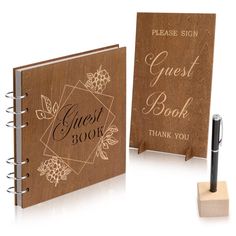 two wooden guest book stands next to each other with a pen in front of them