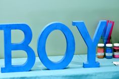 there is a blue sign that says boy next to some paint bottles and a cell phone