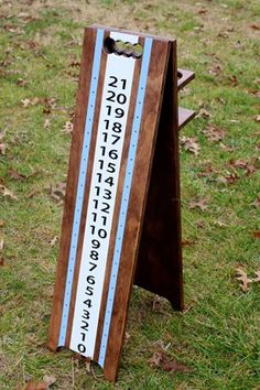 a wooden sign sitting on top of a grass covered field