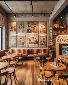 an empty restaurant with posters on the wall and wooden tables, chairs, and couches