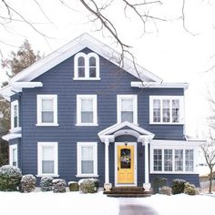 a blue house with white trim and yellow door