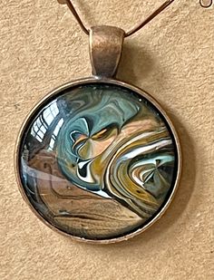 a glass pendant with an abstract design on it