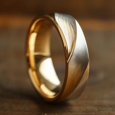 a gold wedding band with an unusual design on the inside, sitting on a wooden surface