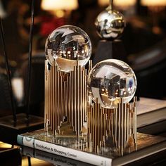 three crystal balls sitting on top of a table next to books and lamp holders with candles in the background