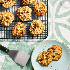 several cookies on a cooling rack next to a blue plate with one cookie in it