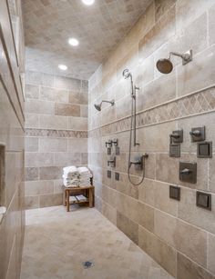 a walk in shower sitting next to a tiled wall and floor covered in white towels