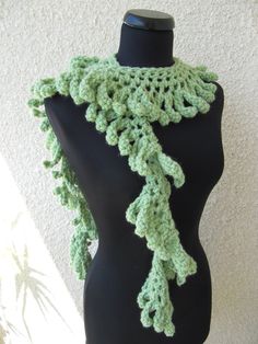 a black mannequin with a green crochet scarf on it