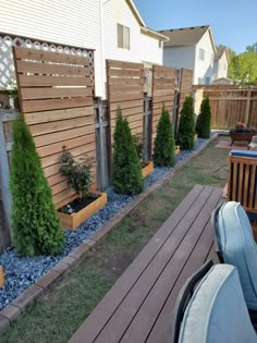 a backyard area with wooden fence and blue rocks in the ground next to a deck