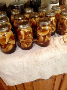 several jars filled with food sitting on top of a white towel next to a wooden cabinet