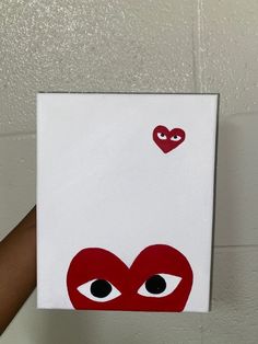 someone is holding up a card with an image of a heart and eyes on it